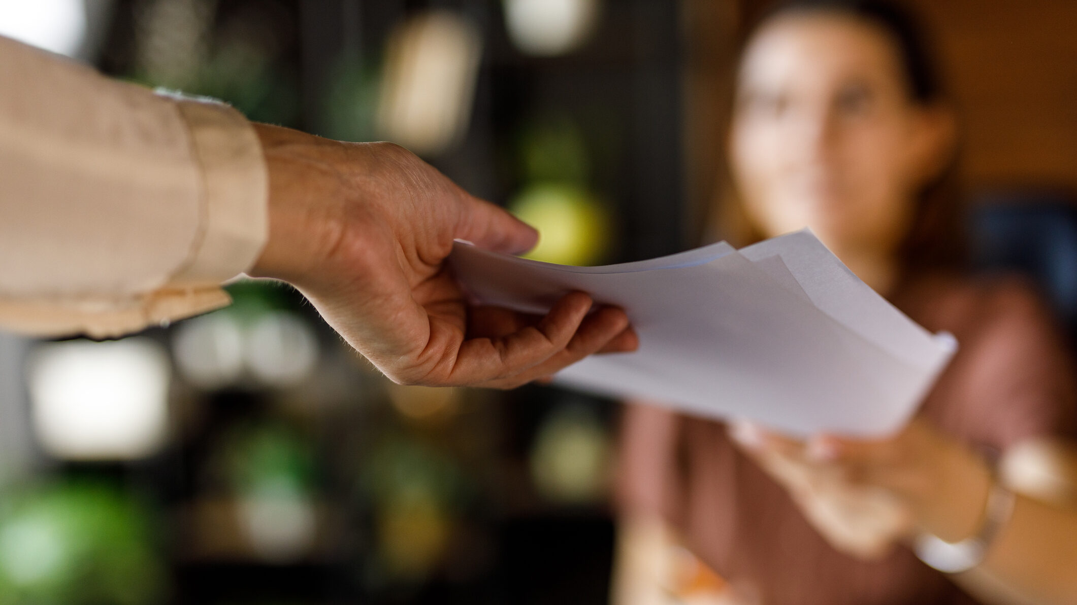Close up shot of unrecognizable businesswoman handing a document to her coworker when co-working in a modern office space.