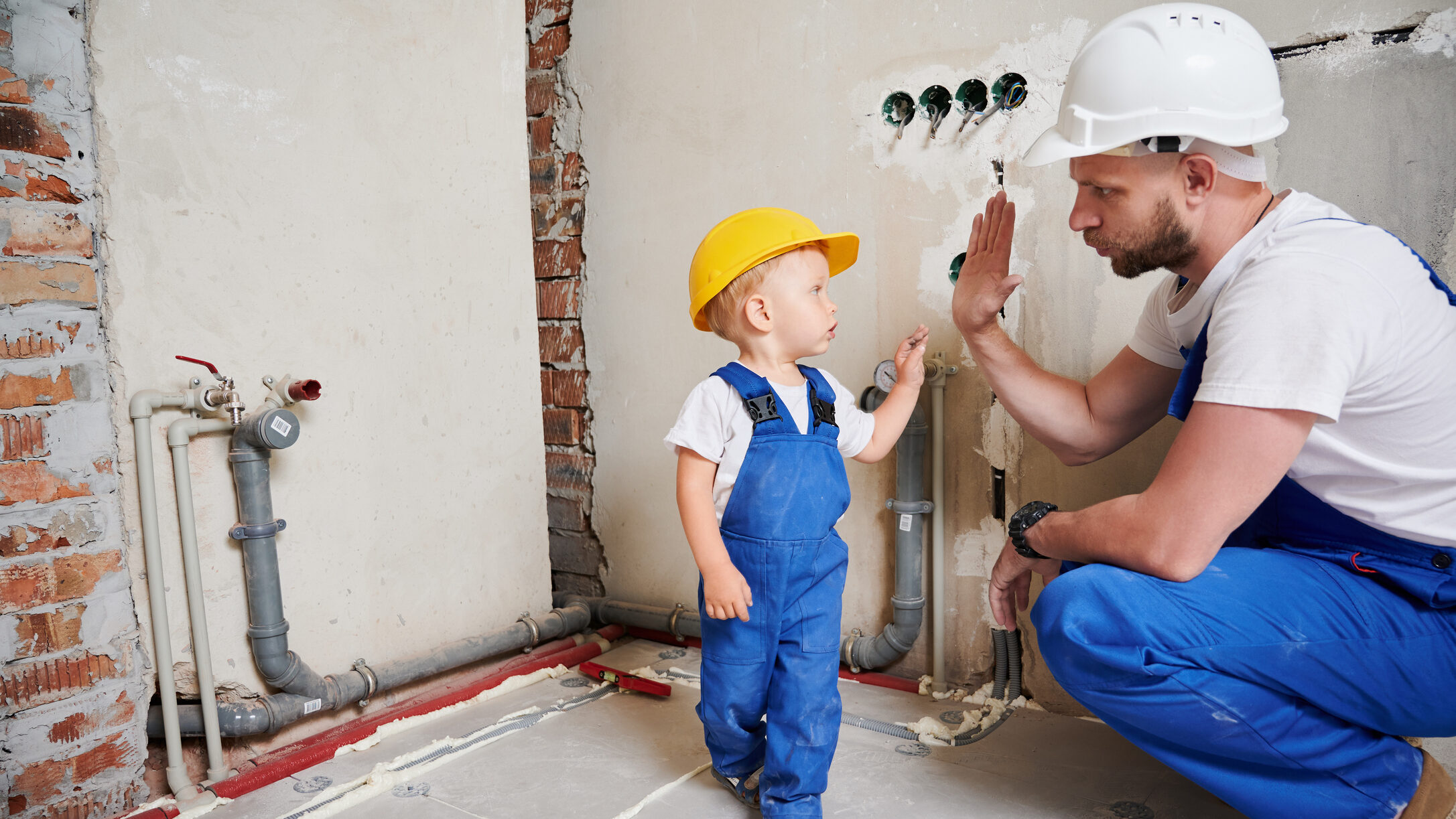 Man and child doing high five gesture at home during renovation.